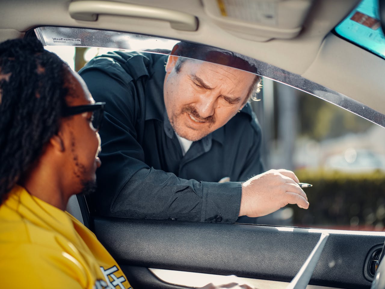 gallery-01 A police officer interacts with a driver through a car window, emphasizing law enforcement and public safety.